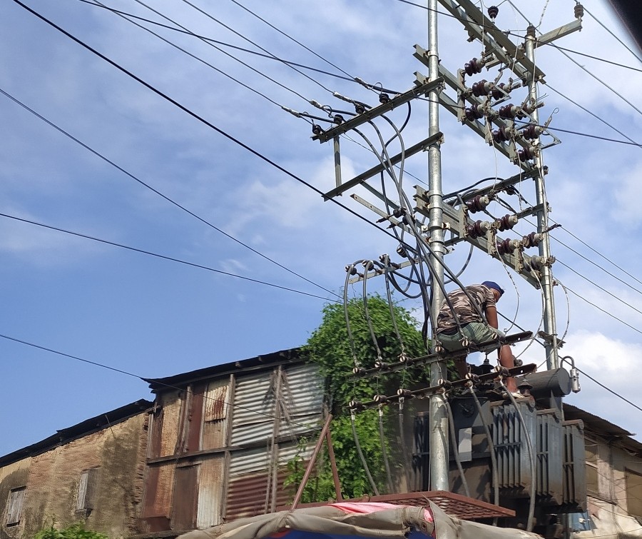 A power department personnel climbs atop a power transformer at Church road, Dimapur in an effort to repair them. (Morung File Photo)